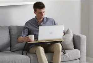 J Burrows lap desk used with a laptop computer on a couch - product image courtesy of Officeworks Australia